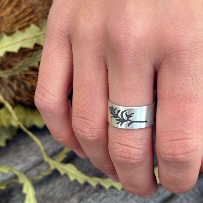 Paintbrush Adjustable Ring on finger, featuring etched wildflower design in matte silver finish.