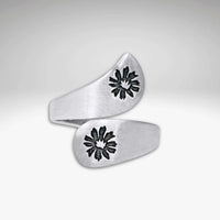 The Bitterroot Bypass Adjustable Ring is a silver wrap-around band with a brushed finish and two bitterroot flower designs at each end.