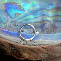Halo Adjustable Ring in Matte Silver, featuring a textured design displayed on a colorful abalone shell.