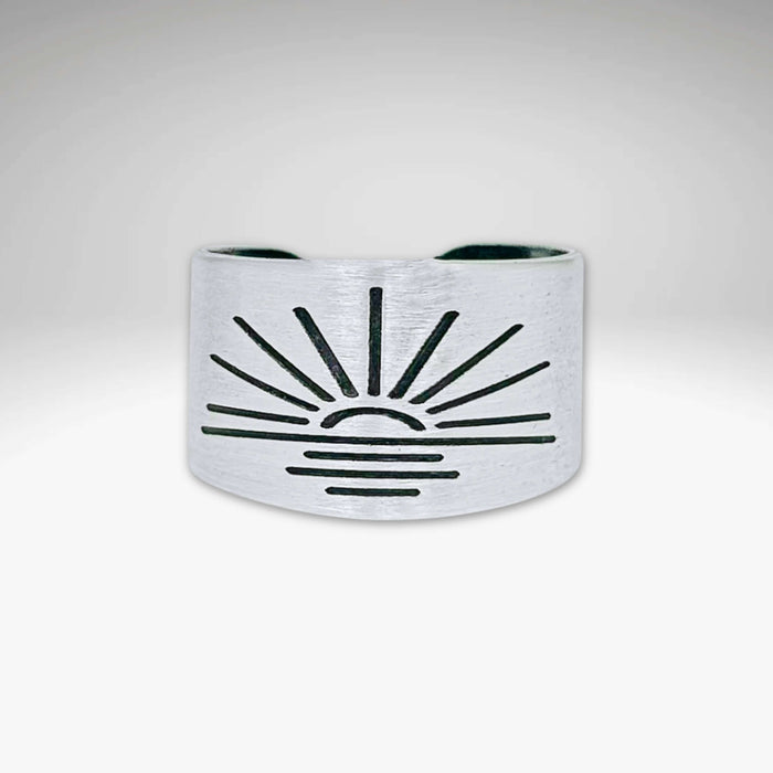 Sunrise Adjustable Ring in matte silver with sunburst design, handmade, adjustable, width 0.5 inches.