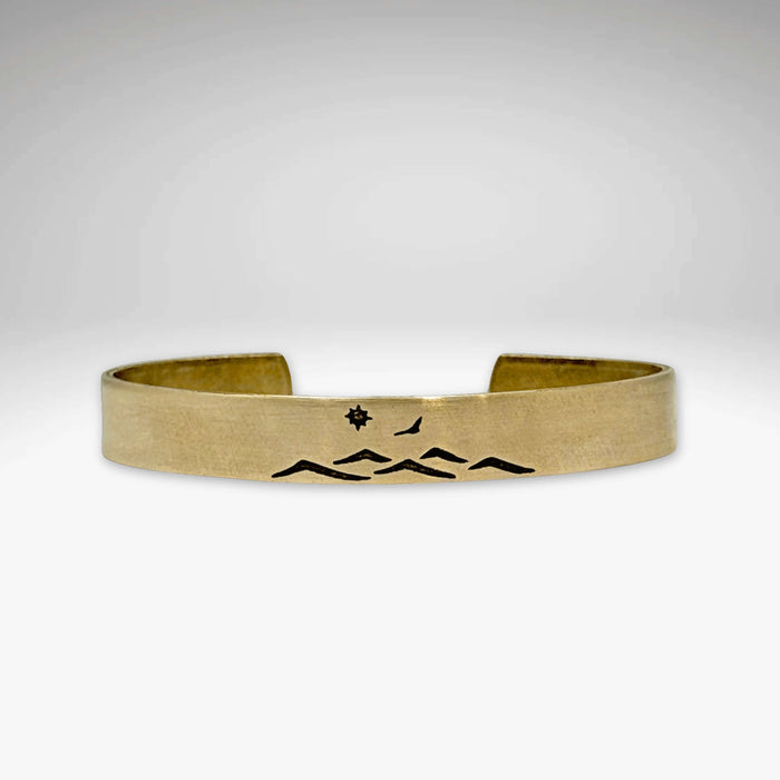 Fly Over cuff bracelet featuring a mountain design, bird, and sun, perfect for men and women, adjustable for comfort.