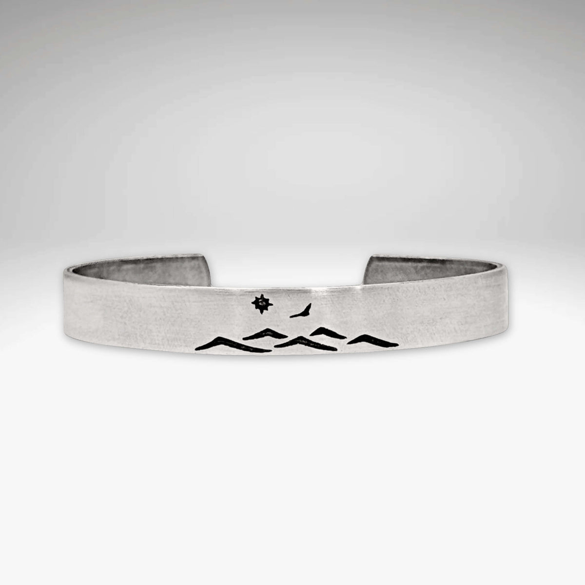 Fly Over cuff bracelet featuring mountain design, bird, and sun, adjustable for men and women, showcasing nature's beauty.