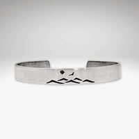 Fly Over cuff bracelet featuring mountain design, bird, and sun, adjustable for men and women, showcasing nature's beauty.