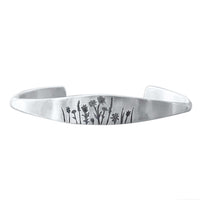 Wildflowers Signet Cuff featuring intricate wildflower engravings on a sleek metal cuff bracelet.