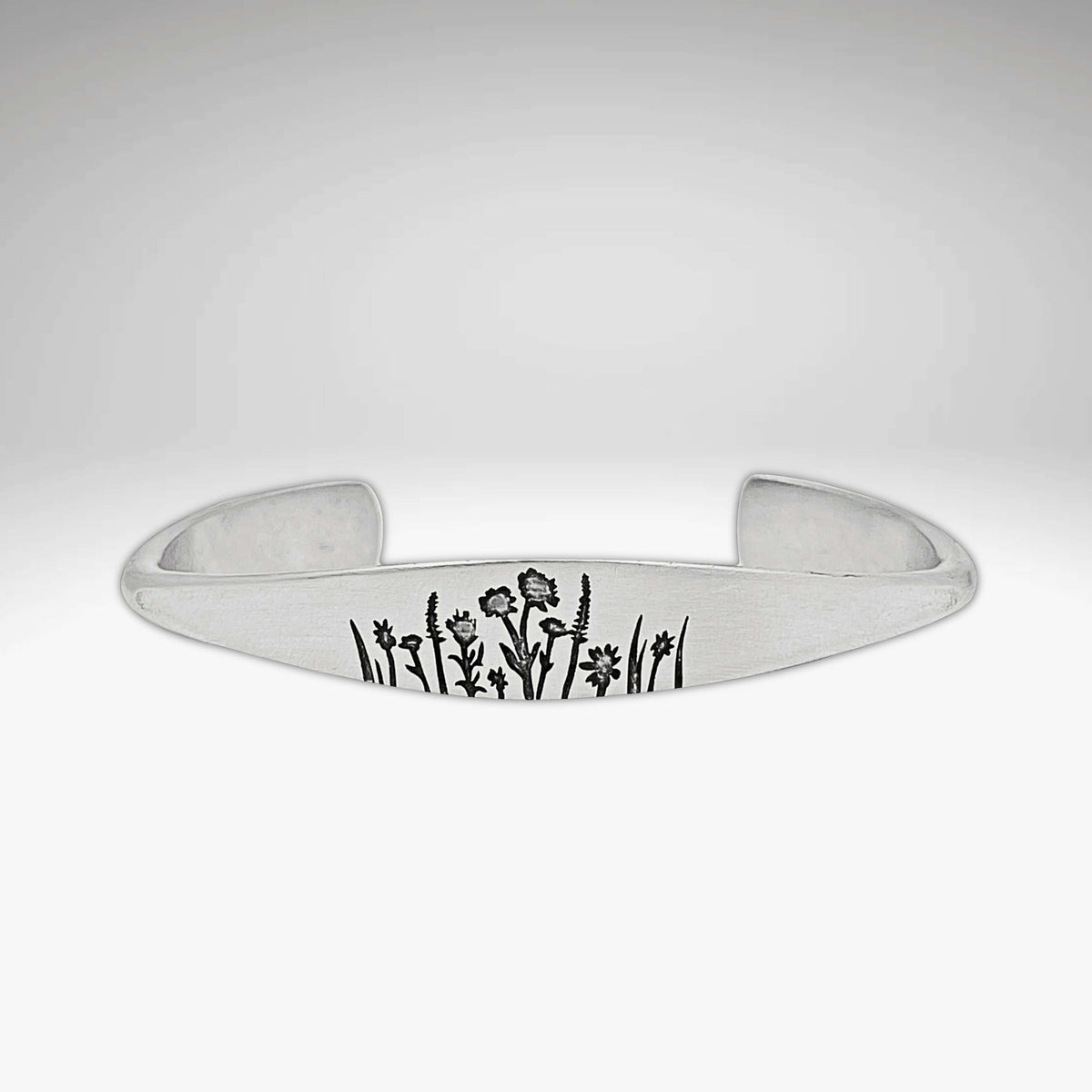 Wildflowers Signet Cuff featuring engraved wildflower design on a sleek silver cuff bracelet.