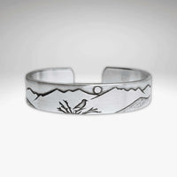 Mtn Bluebird Cuff Bracelet featuring intricate mountain and bluebird designs, crafted from raw brass.