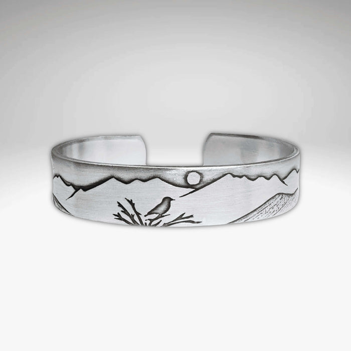 Mtn Bluebird Cuff Bracelet featuring intricate mountain and bluebird designs, crafted from raw brass.