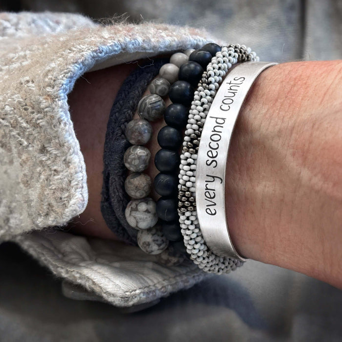 Every second counts - Bear Cuff Bracelet worn with beaded bracelets, showcasing adjustable raw brass design.