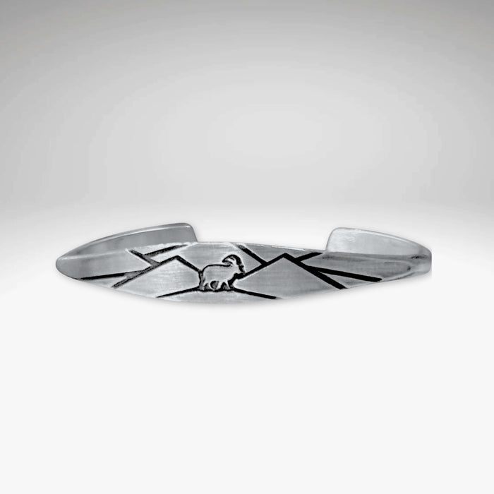 Handcrafted mountain goat cuff bracelet in matte silver, featuring rugged mountain designs for confident styling.