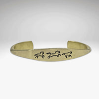 Wild Horses cuff bracelet in antique brass showcasing galloping horse designs, elegant and timeless jewelry piece.