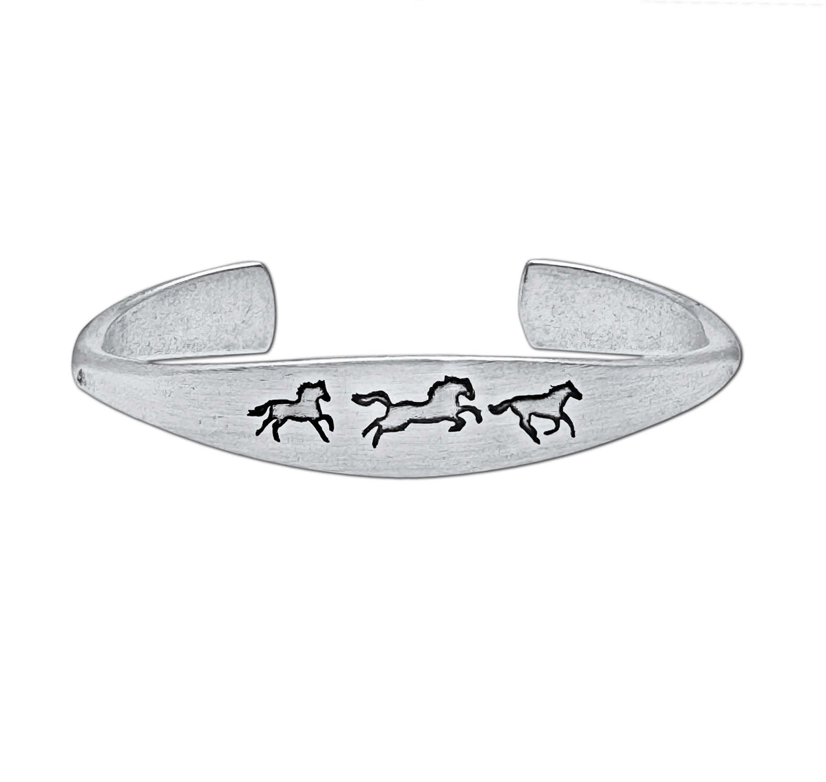 Wild Horses cuff bracelet in matte silver with three galloping horse designs, a timeless and elegant accessory.