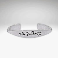 Wild Horses cuff bracelet in matte silver with three galloping horse designs, a timeless and elegant accessory.