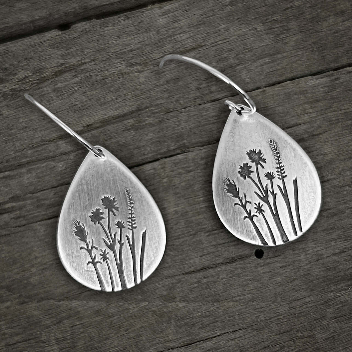 Wildflower Earrings featuring etched wildflower designs on silver teardrop dangle earrings.