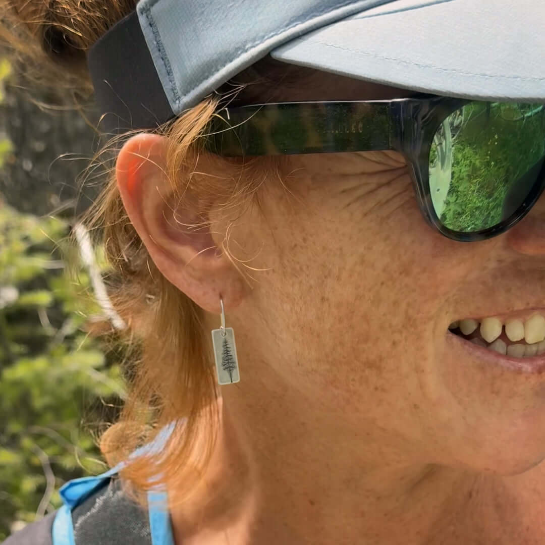 Woman wearing P Pine Tree Earrings, showcasing their unique design and nature-inspired elegance.