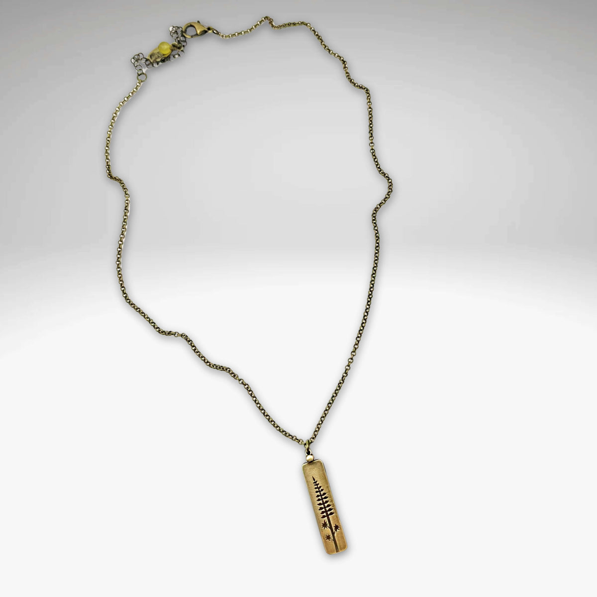 Lupine Necklace featuring a gold pendant on an adjustable rolo chain, perfect for sunny days or casual wear.