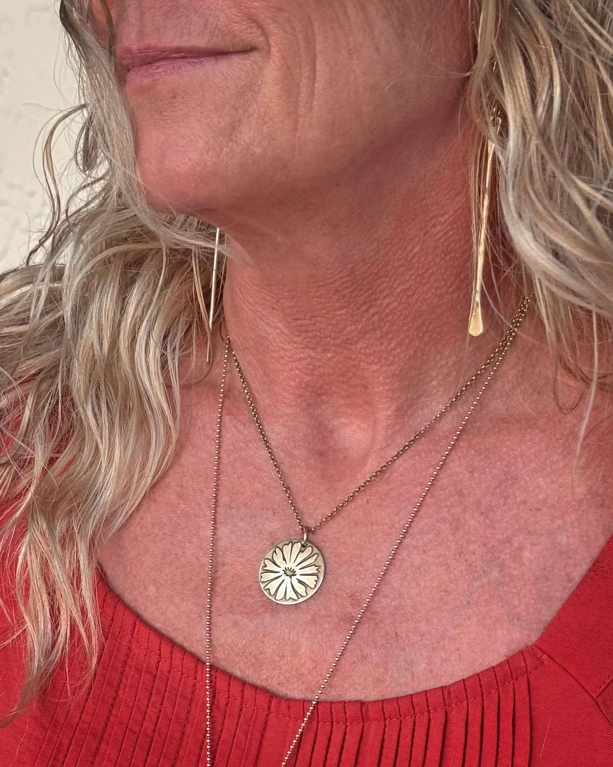 Woman wearing Bitterroot Necklace with a floral pendant, showcasing the necklace's delicate design.