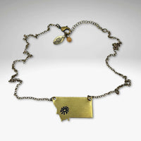 Montana outline pendant with a Bitterroot flower in antique brass on a gold plated 18" chain.