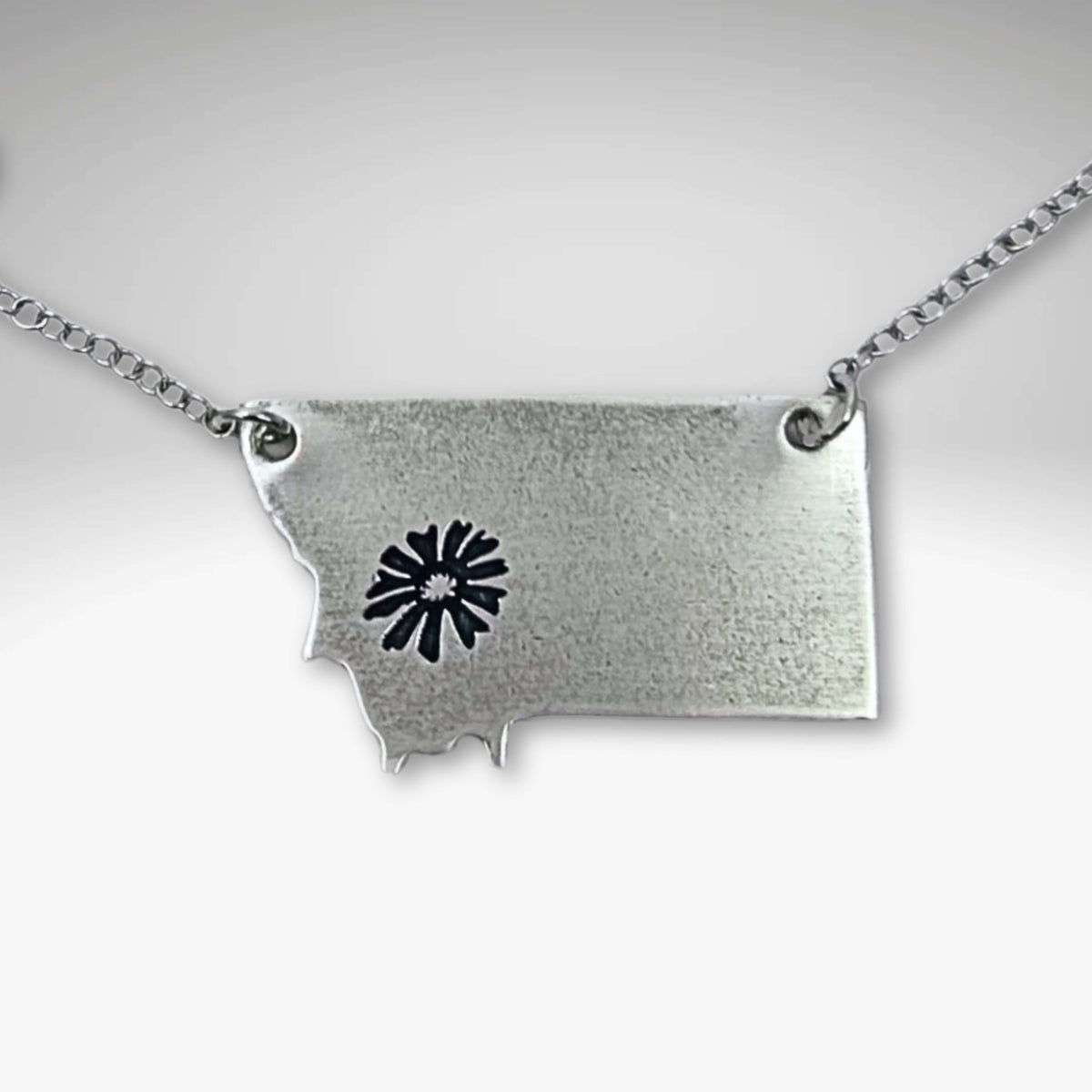 Montana outline pendant with a Bitterroot flower in Matte Silver and on a simple cable chain.