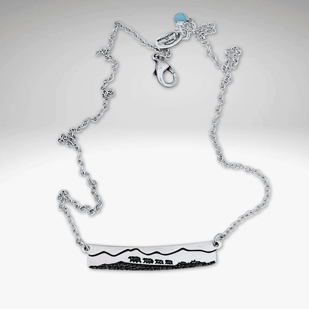 Bear Family Necklace in Matte Silver featuring a mama bear and cubs against a mountain backdrop.