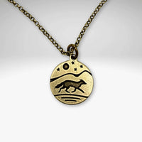Antique brass Fox pendant with running fox with mountains, moon and stars in the background.