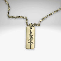Pine Tree Necklace featuring a pendant design inspired by the Ponderosa Pine, available in Matte Silver and Antique Brass.