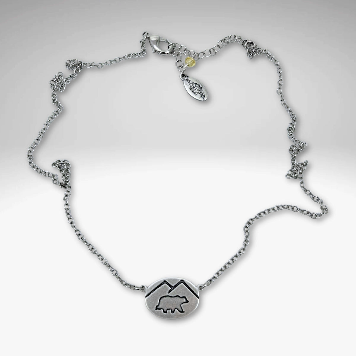 Mountain Bear Necklace in matte silver finish with a bear pendant and adjustable chain length.