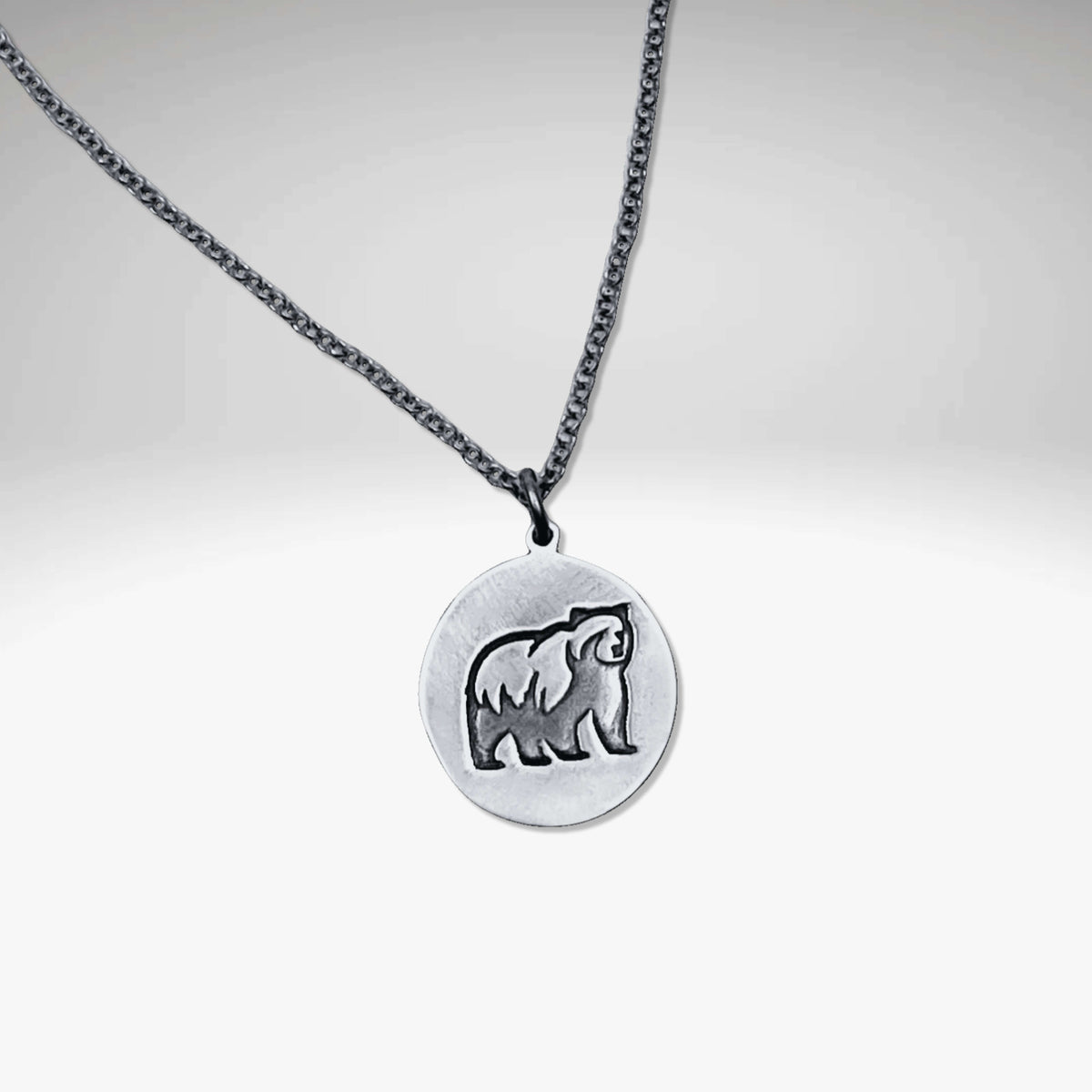 Grizzly bear pendant in matte silver featuring a grizzly bear design on a rolo chain, handmade in Montana.