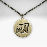 Brass round disc with a silhouette of a grizzly bear on a simple chain