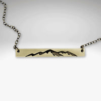 Mountainscape Necklace featuring a raw brass bar with an etched mountain silhouette, adjustable cable chain.