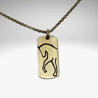 White Horse Necklace on a dainty chain, featuring a designed silhouette etched on raw brass.