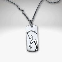 Silver pendant necklace featuring a sleek etched silhouette of a rearing horse.