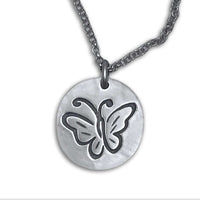 Butterfly necklace pendant featuring an etched butterfly design on a silver disc with an adjustable chain.