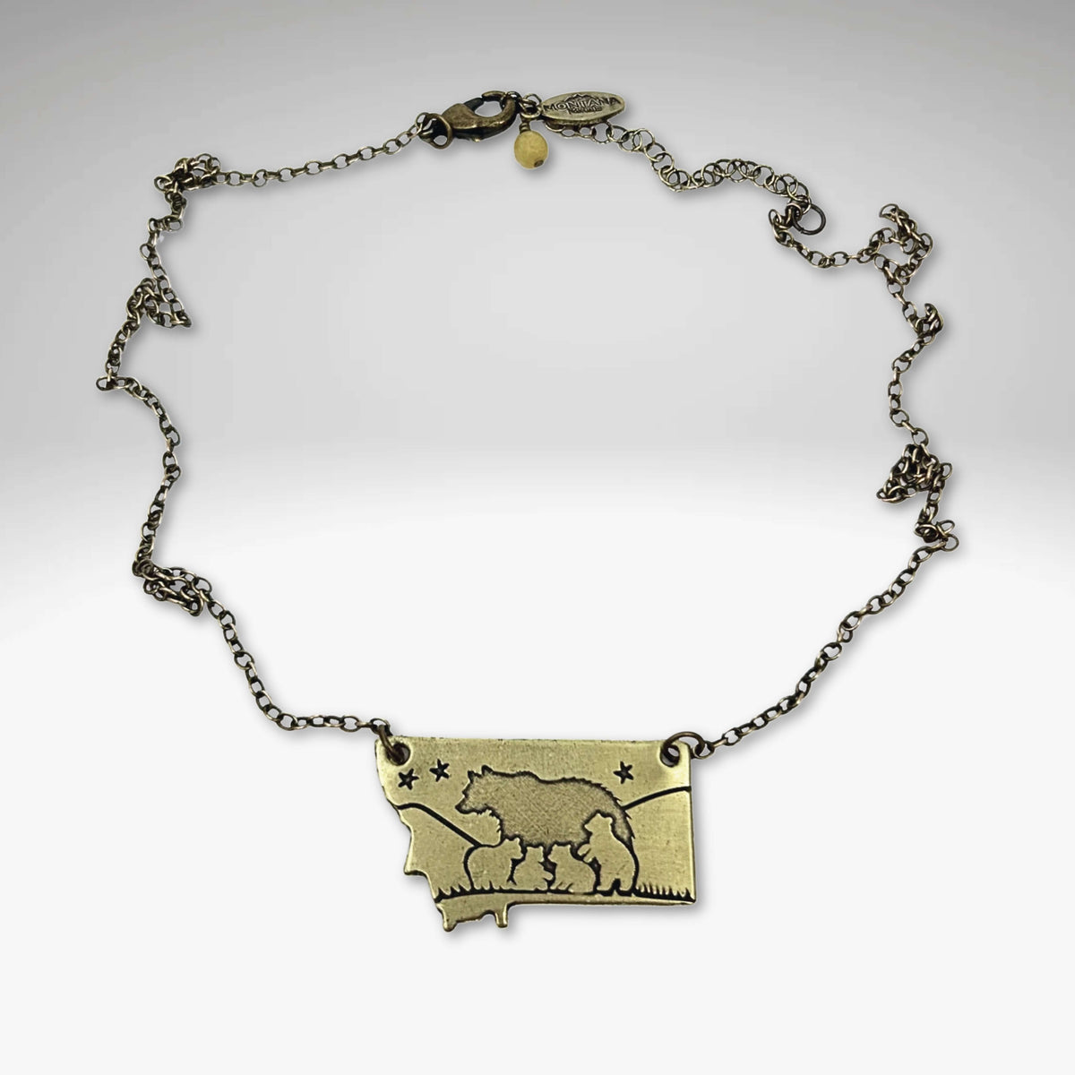 Montana outline pendant with a mama bear and four cubs in Antique Brass on a gold plated chain.