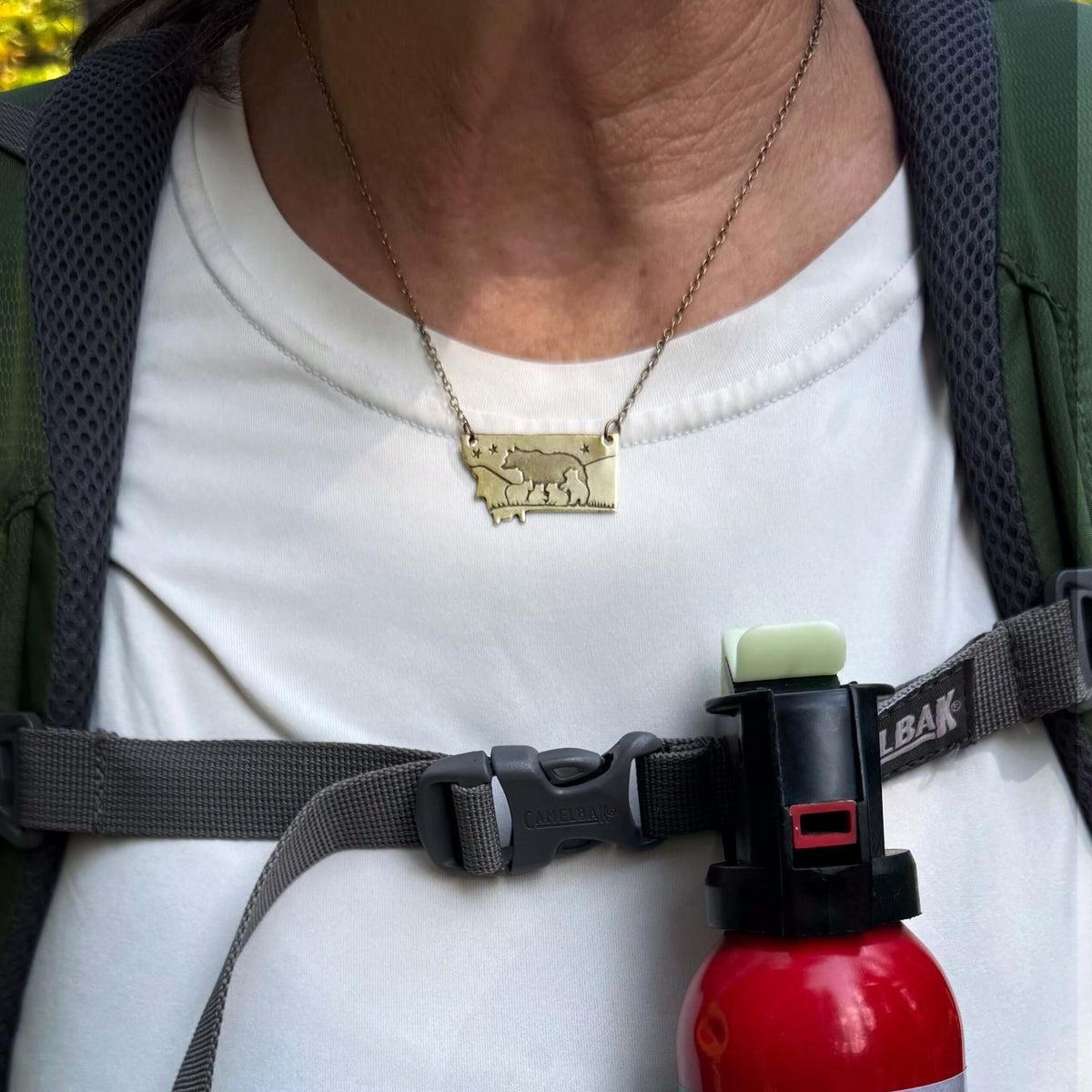 Four Cubs - Montana Bear Necklace worn on a person's neck, showcasing the antique brass finish.