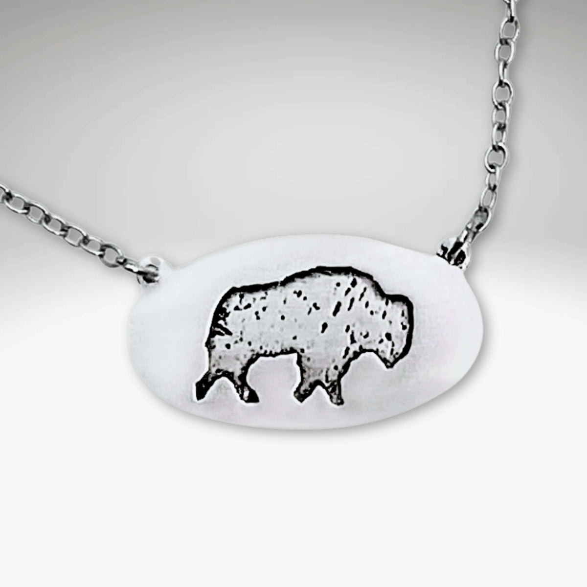 Roam Free Necklace featuring a buffalo design, perfect gift for nature lovers in Matte Silver and Antique Brass finishes.