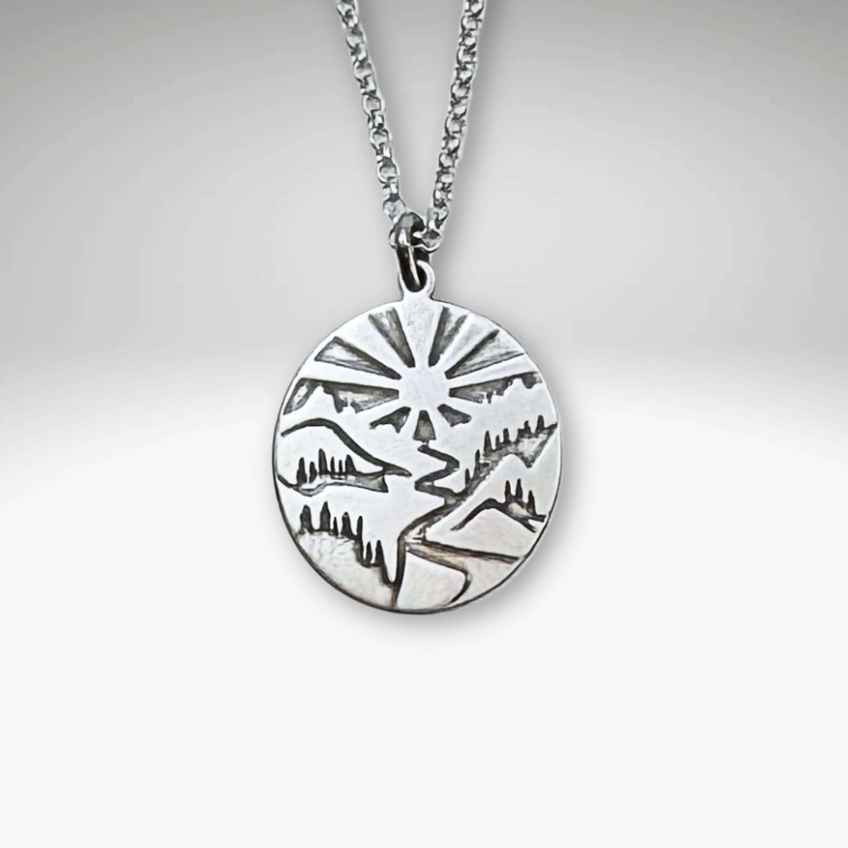 Going to the Sun Necklace pendant in silver, featuring a mountain landscape design, inspired by Glacier National Park.