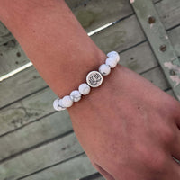 Lotus Stretch Bracelet - Gemstone Beaded Stretchy Bracelet with white beads and lotus charm on wrist.