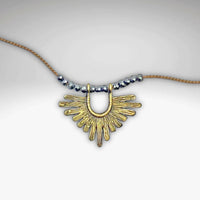 Sunbeam Necklace featuring a geometric gold pendant on a silk cord with crystalline hematite beads, adjustable length.