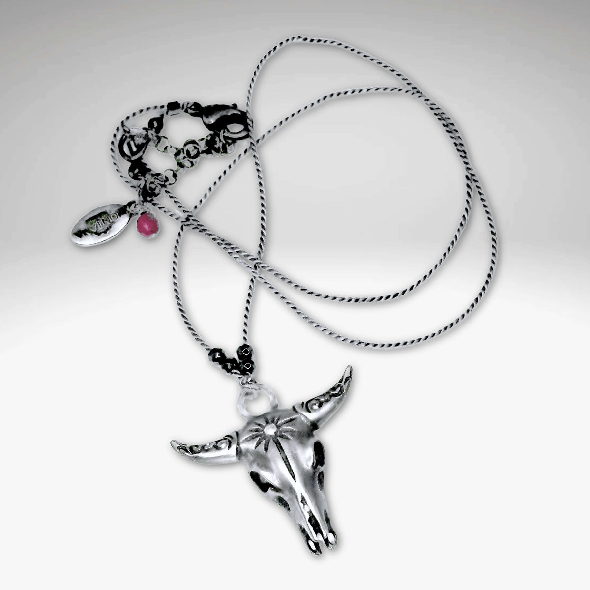 Bison skull necklace on delicate silk cord with hematite beads, available in matte silver finish.