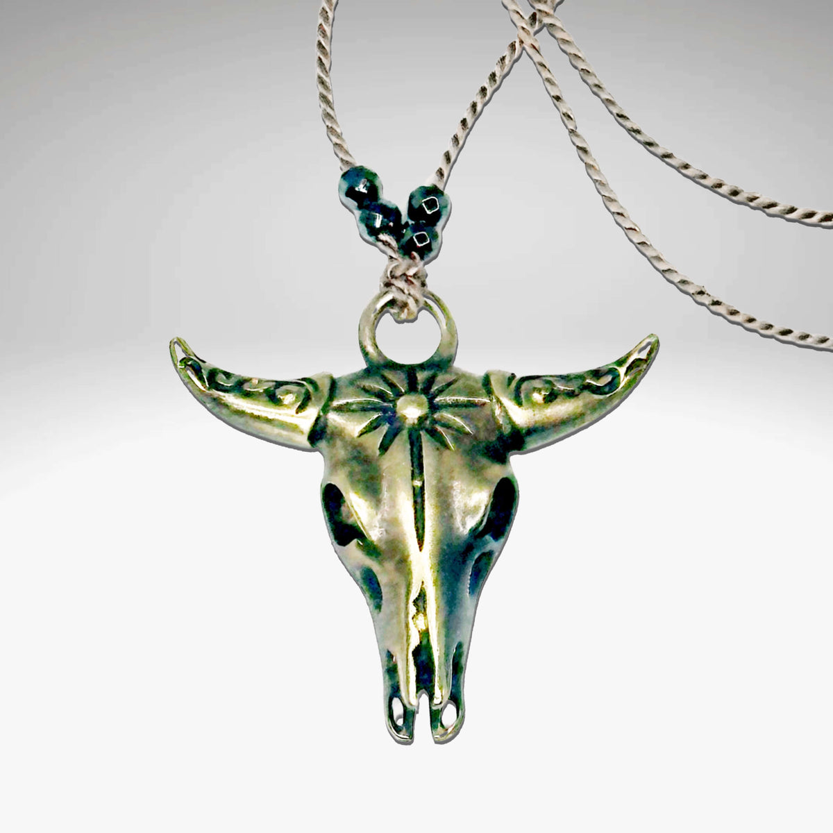 Bison Skull Necklace with geometric pendant on silk cord and hematite beads, adjustable length, in antique brass finish