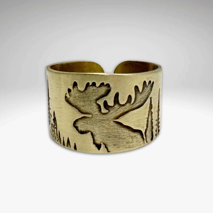 Creek Moose Adjustable Ring in antique brass showcasing a moose silhouette against a forest backdrop.