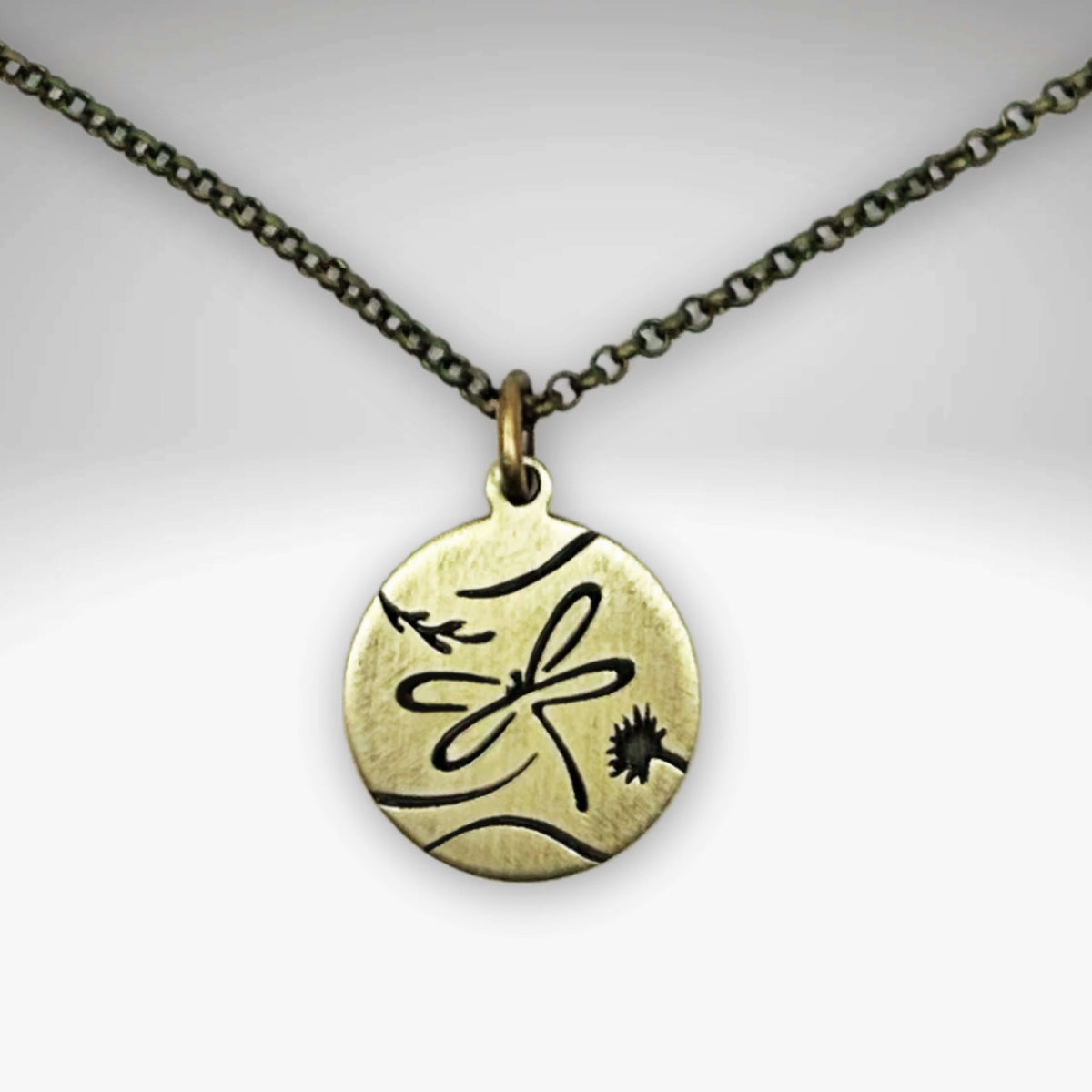 Antique brass dragonfly pendant on an adjustable chain, showcasing delicate nature-inspired design.