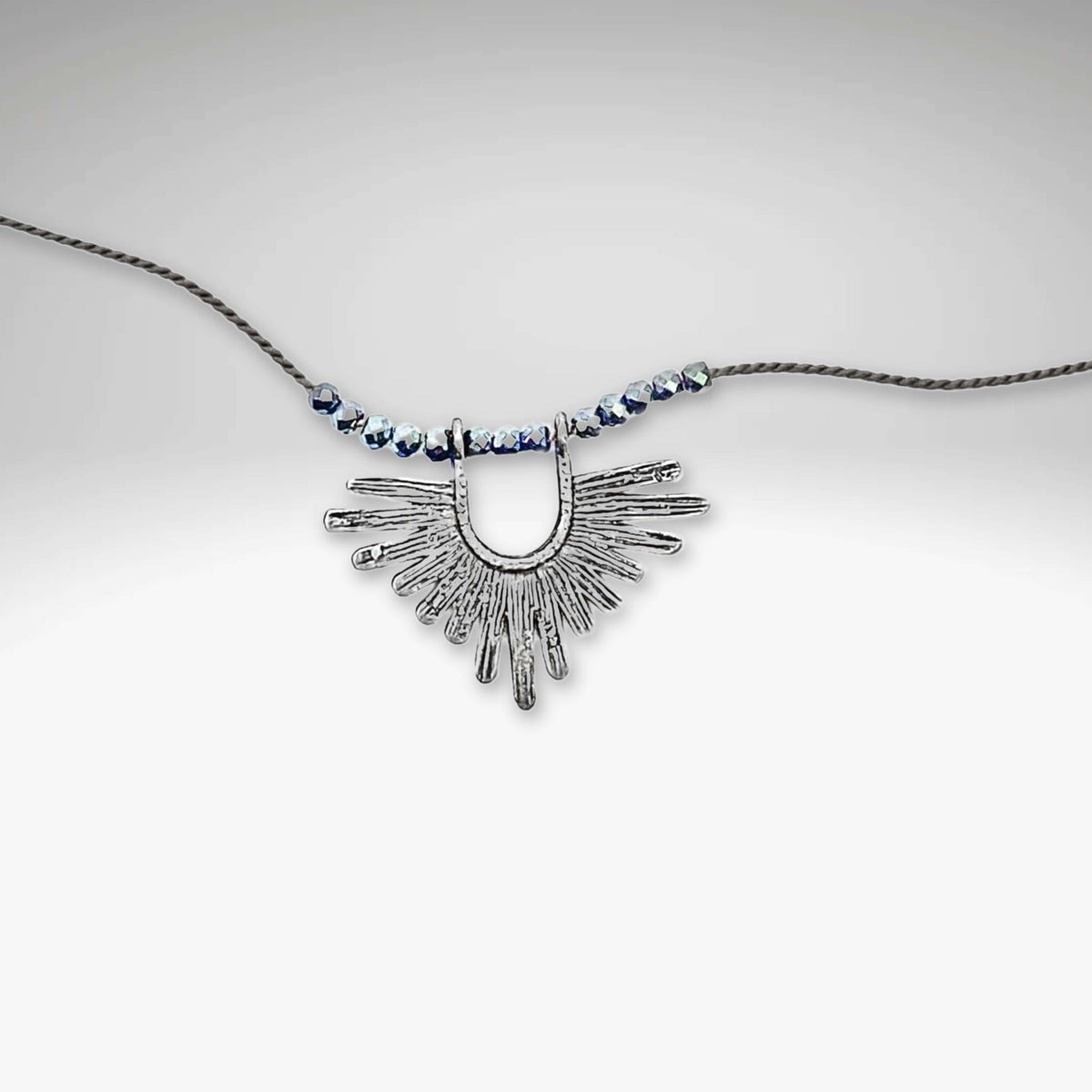 Sunbeam Necklace featuring geometric design, hematite beads, and adjustable silk cord from 16" to 18".