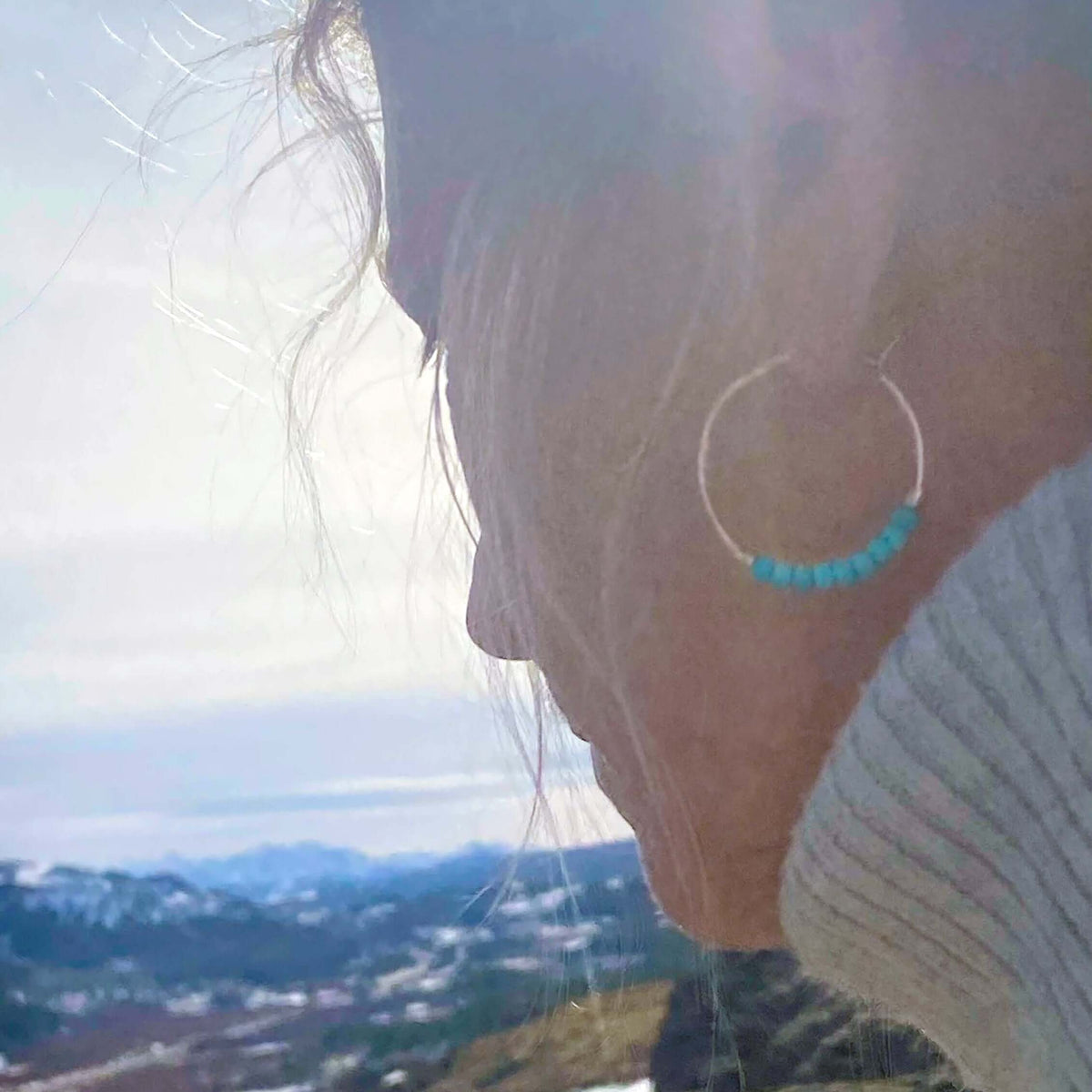 Shun Howlite Beaded Hoop Earrings worn by model outdoors with turquoise howlite beads in sterling silver hoops.