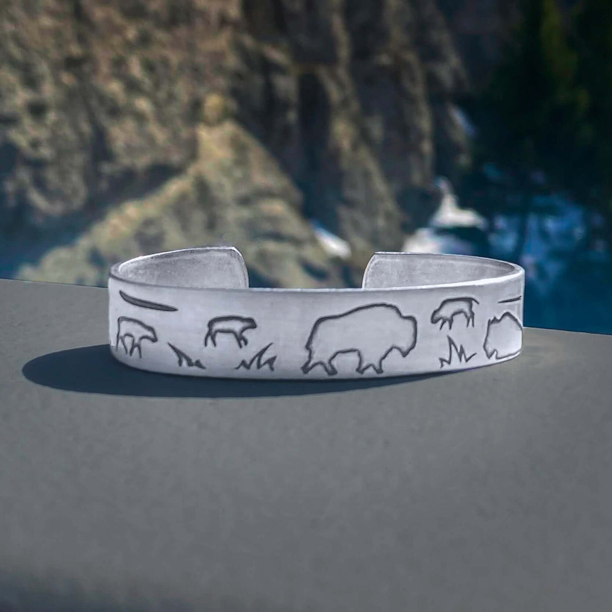 Buff and Babes Cuff Bracelet showcasing bison designs against a scenic backdrop, perfect for celebrating new beginnings.
