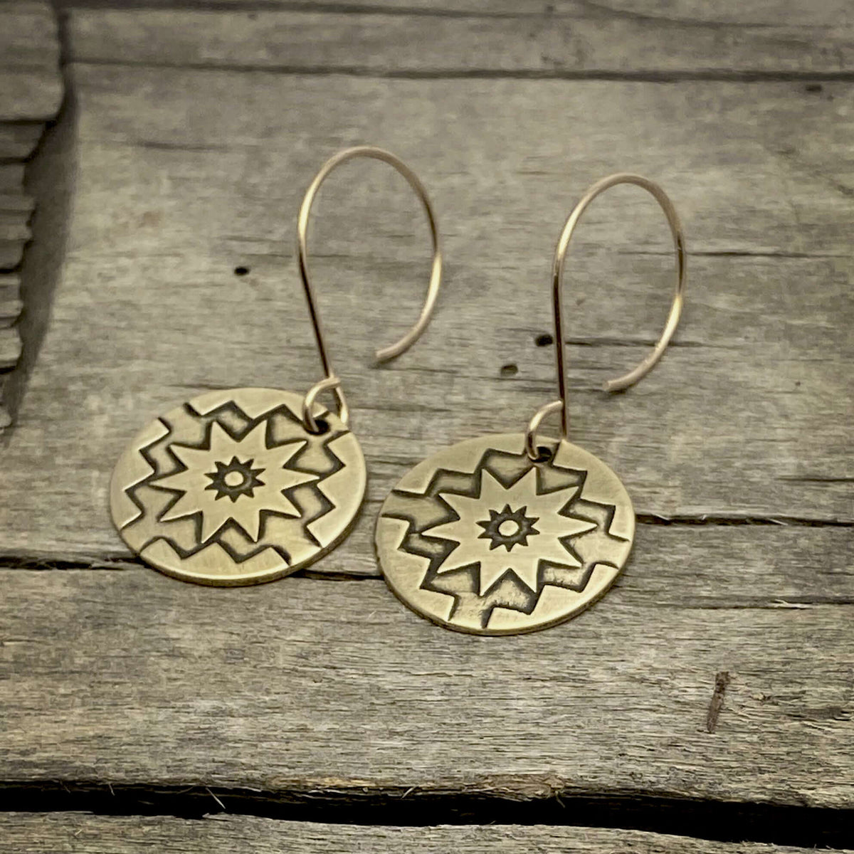 Northstar Earrings featuring etched star design with 14k gold filled earwires on rustic wood background.