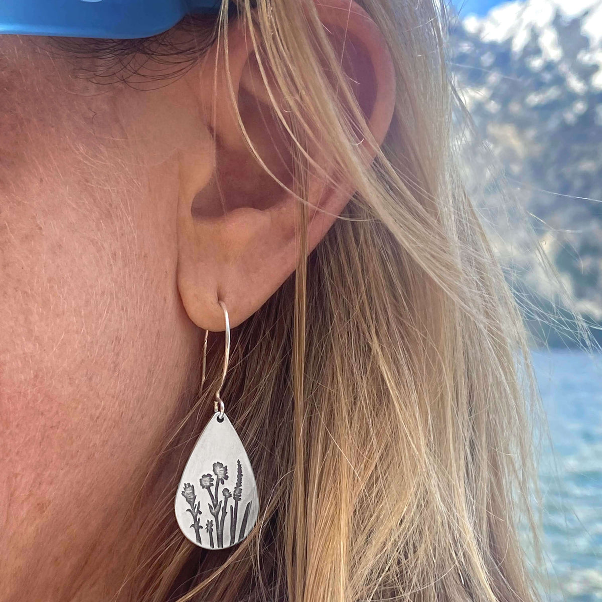Close-up of a person wearing Wildflower Earrings with delicate floral designs, inspired by Rocky Mountain wildflowers.