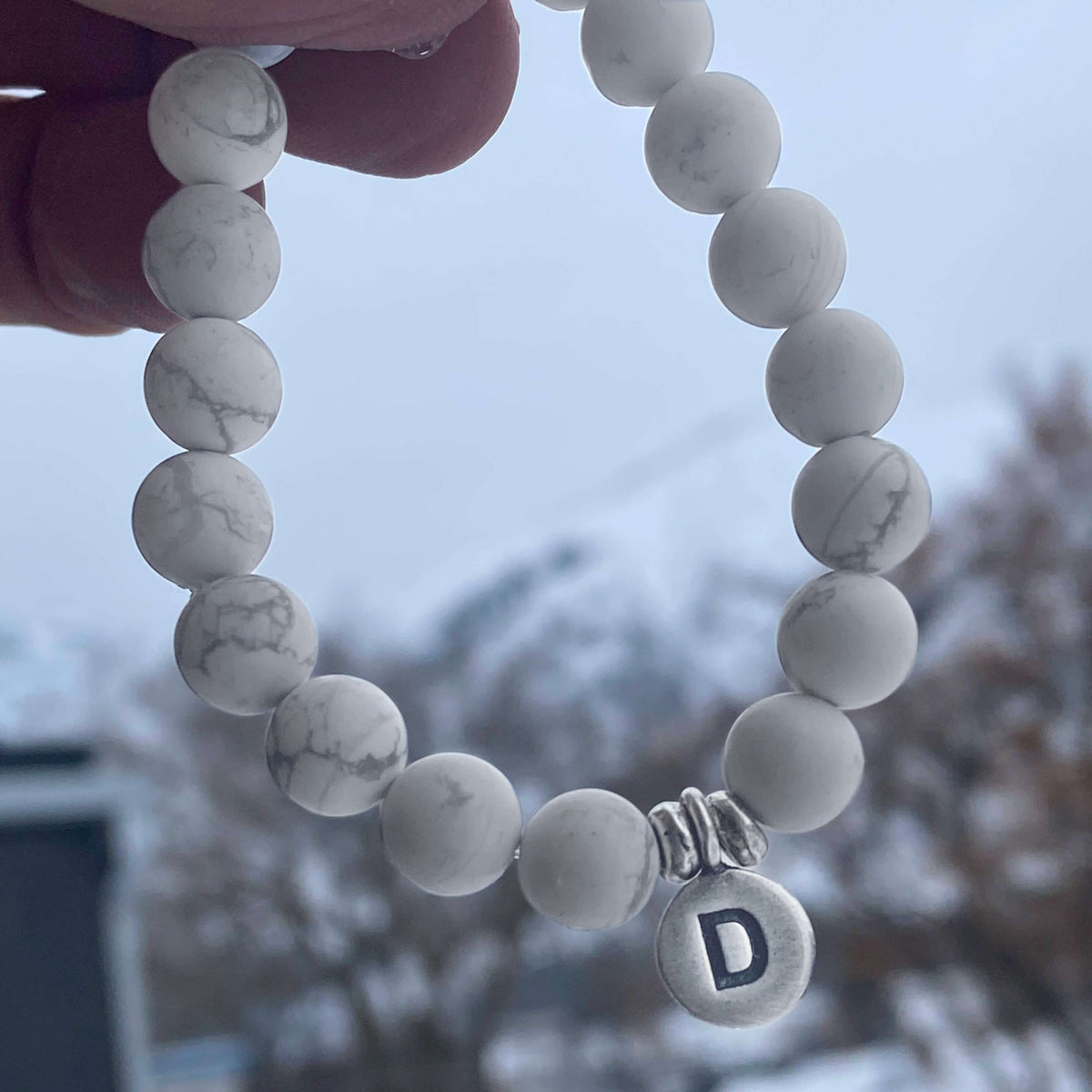 Initial Stretch Bracelet Collection featuring a personalized white Howlite bracelet with initial 'D' charm.