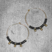 Dew Drops Earrings featuring elegant hematite and beaded hoop design in Matte Silver and Antique Brass finishes.
