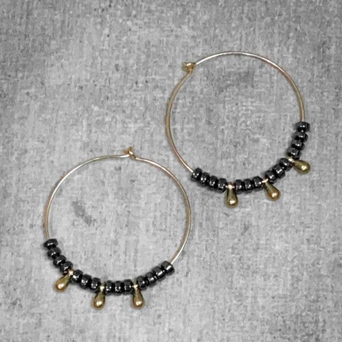 Dew Drops Earrings featuring elegant hematite and beaded hoop design in Matte Silver and Antique Brass finishes.